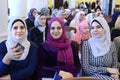 Three attractive Muslim women communicating sitting in a hall of Woman International Forum