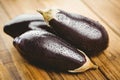 Three aubergines on wooden board Royalty Free Stock Photo