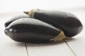 Three aubergines on wooden board Royalty Free Stock Photo