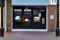 Three automated cash dispensers ATMs with illuminated screens outside a branch of the HSBC bank