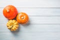 Three autumn pumpkins on white wooden background. Top view. Halloween concept with free space for text Royalty Free Stock Photo