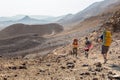 Three backpackers walking stone desert trail.