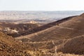 Three backpackers walking stone desert trail.