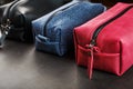 Three bags, black, blue and red with genuine leather locks on a black background Royalty Free Stock Photo