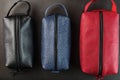 Three bags, black, blue and red with genuine leather locks on a black background Royalty Free Stock Photo