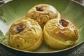 Three baked apples in a green bowl