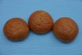 Three baked brown rolls on a blue table Royalty Free Stock Photo