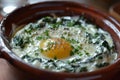 Three baked eggs over spinach in ceramic dish. Neural network AI generated Royalty Free Stock Photo