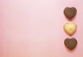 Three baked heart shaped cookies on pink background