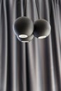 Three ball shaped LED illuminators are hanging from the ceiling. Black curtain on the backround Royalty Free Stock Photo