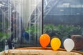 Three balloon in front of glass with glass cleaner behind