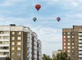 Three balloons over the roofs of city houses