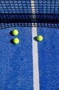 three balls near the net in a blue paddle tennis court, racket sports concept Royalty Free Stock Photo