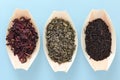 Three bamboo bowls with Hibiscus, Black and Green tea, on blue background