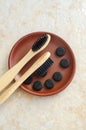 Three bamboo toothbrushes with black bristles and activated charcoal tablets. Eco friendly toiletries set. Natural dental care