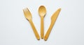 Three bamboo utensilsâa fork, spoon, and knifeâare arranged side by side on a whit Royalty Free Stock Photo