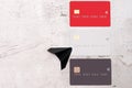 Three bank cards on a light background. Near paper planes. The concept of movement and waste of money.