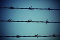 Three barbed wire lines and light blue background Royalty Free Stock Photo