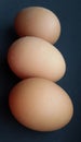 Three barn eggs over black. Fresh chicken eggs.