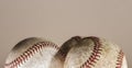 Three baseballs on a tan background