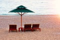 Three beach chairs with green sun umbrella at ocean front. Perfect vacation concept. Coastal landscape. Rest with comfort Royalty Free Stock Photo