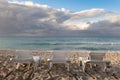 Three beach chairs at ocean front with dramatic sky clouds