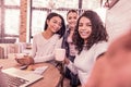 Three beaming women smiling while making photo spending morning in bakery