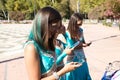 Three beautiful adult belly dancers are checking their mobile phones. They are looking at messages, e-mails and photos. Mobile