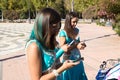 Three beautiful adult belly dancers are checking their mobile phones. They are looking at messages, e-mails and photos. Mobile