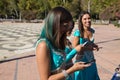 Three beautiful adult belly dancers are checking their mobile phones. They are looking at messages, e-mails and photos. Mobile