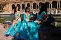 Three beautiful adult belly dancers are sitting on a park bench. They are talking and having fun with each other. Concept of