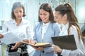 Three beautiful business women discussing paperwork in office Royalty Free Stock Photo