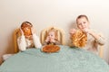 Three beautiful children sit at table in the kitchen and eat large round pancakes. Carnival Festival Royalty Free Stock Photo