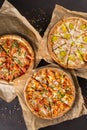 three beautiful colorful juicy different pizzas lie on parchment Royalty Free Stock Photo