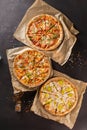 three beautiful colorful juicy different pizzas lie on parchment Royalty Free Stock Photo