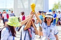 Three beautiful football fans from Asia with a football cup make a safe against the backdrop of the stadium at the World Cup