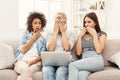 Three beautiful frightened women using laptop at home