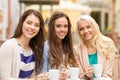 Three beautiful girls drinking coffee in cafe