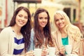 Three beautiful girls drinking coffee in cafe