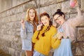 Three beautiful girls eat lollipops and drink lemonad in pink bottle. Girlfriends with different hairstyles. Friends, woman Royalty Free Stock Photo