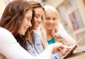 Three beautiful girls looking at tablet pc in cafe Royalty Free Stock Photo