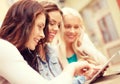 Three beautiful girls looking at tablet pc in cafe Royalty Free Stock Photo