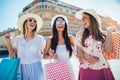 Beautiful girls in sunglasses with shopping bags in city Royalty Free Stock Photo