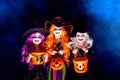 Three Beautiful girl in a witch costume on a dark background in smoke scaring and making faces Royalty Free Stock Photo