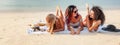 Three beautiful happy young women girlfriends on the seashore in bikini standing lying on a tropical beach enjoying vacation