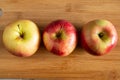 three beautiful red-yellow apples lying on a wooden background Royalty Free Stock Photo