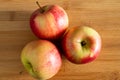 three beautiful red-yellow apples lying on a wooden triangle background Royalty Free Stock Photo