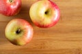 three beautiful red-yellow apples lying on a wooden triangle background Royalty Free Stock Photo