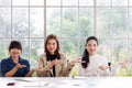 Three beautiful and self-confident businesswomen sitting in office and showing hand sign language skill in the same action Royalty Free Stock Photo