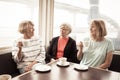 Three beautiful senior women enjoying retirement together having tea or coffee Royalty Free Stock Photo